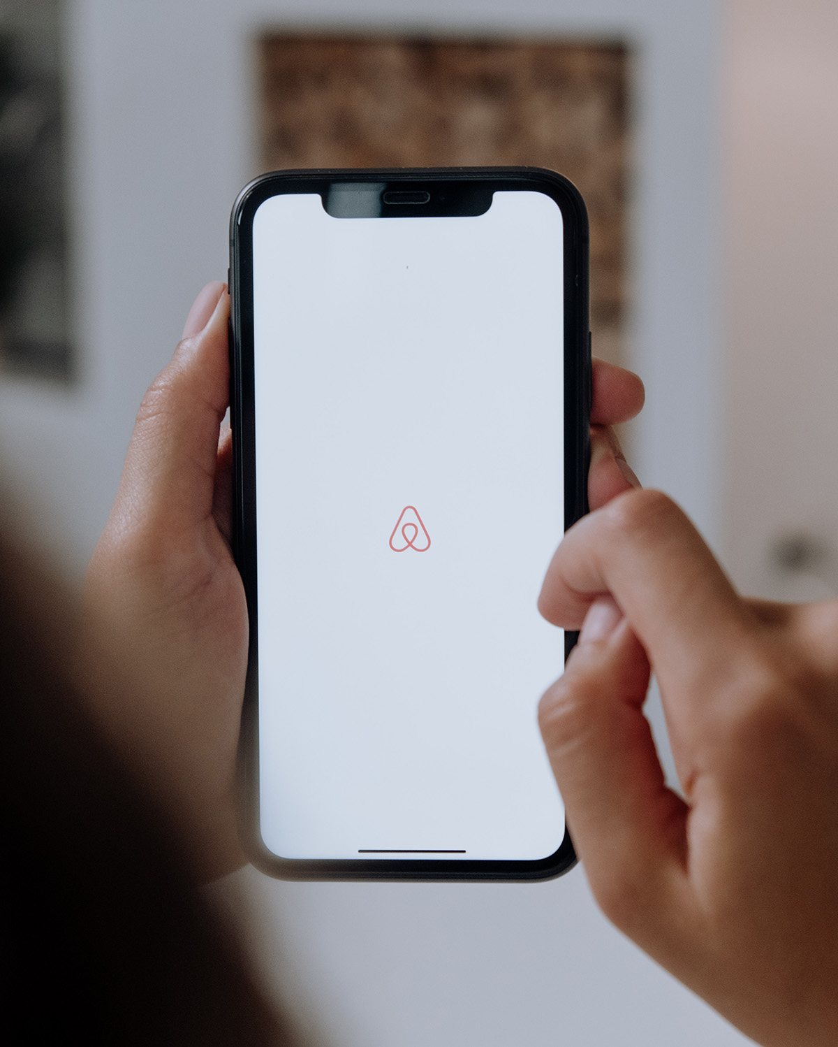 A person loads the Airbnb app on their mobile phone.