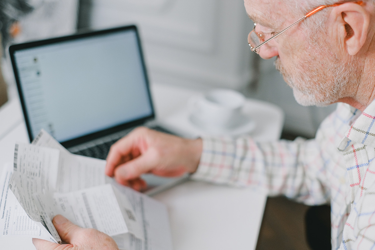 Elderly man reviews his tax documentation.