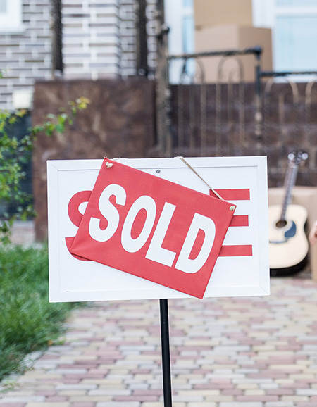 brokerage-investing-services-sold A bright red 'sold' sign on top of a sign that said 'sale'