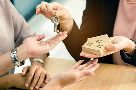 New homeowners being handed keys by a realtor