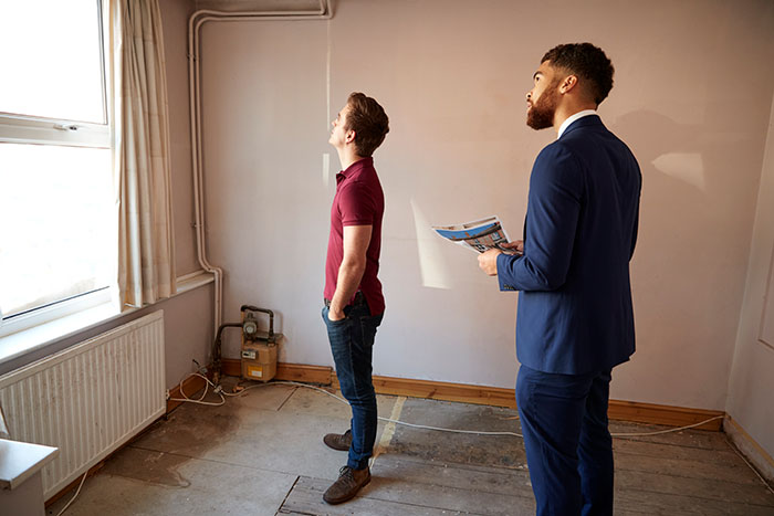 home buyer looking at a house for renovations with real estate agent