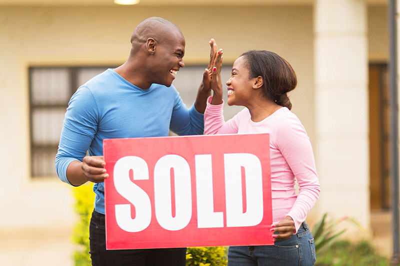 couple high-fiving in celebration of the purchase of a home